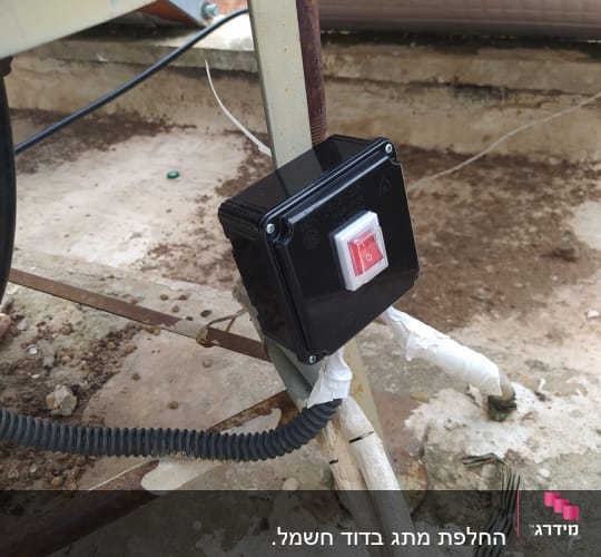מתג חשמלי מותקן על מתקן מתכת, חוטים מחוברים